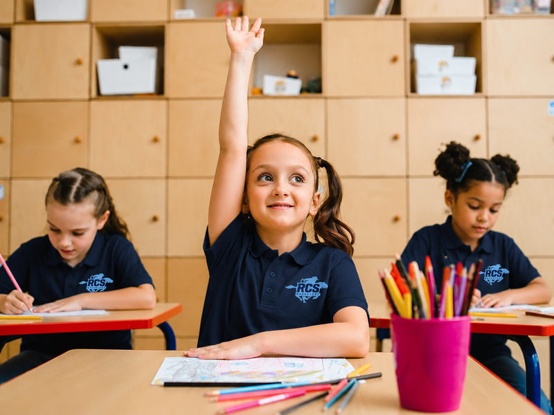Girl in classroom raising hand